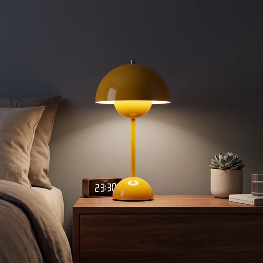 Aesthix Lume Bud yellow retro table lamp glowing on a wooden bedside cabinet.