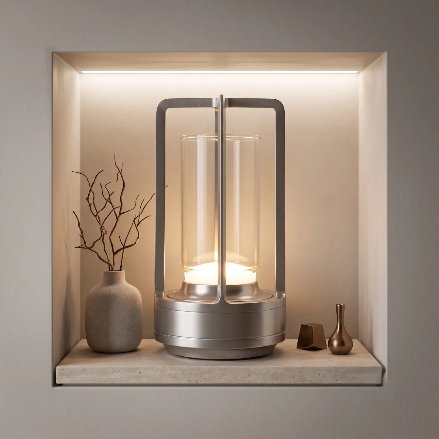 Aesthix Lume Luxe glass lantern table lamp glowing on a recessed stone shelf niche with decorative vases