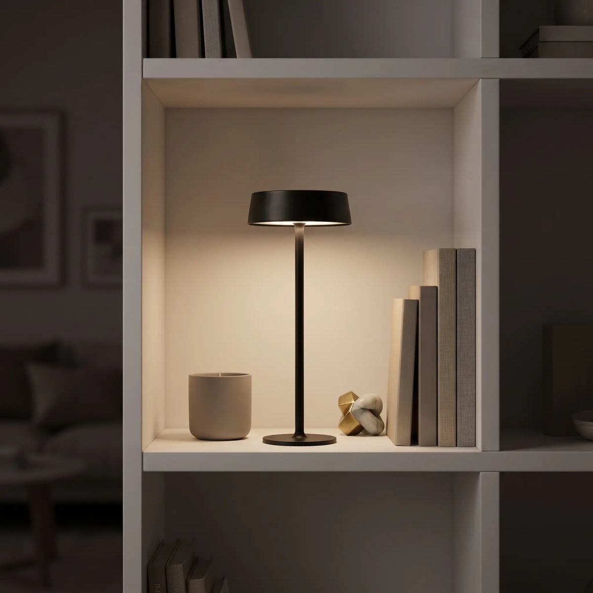 Aesthix Lume Plate black Nordic touch table lamp on a styled bookshelf with books and decor