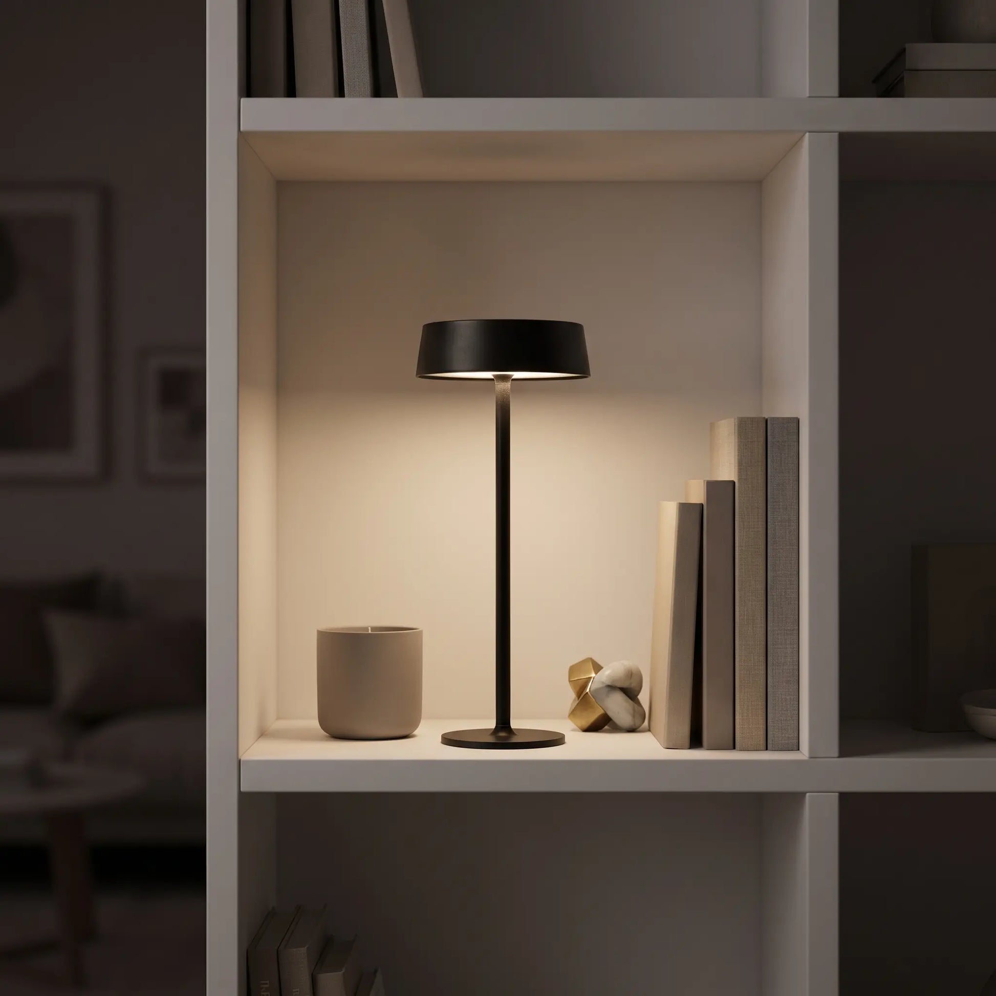 Aesthix Lume Plate black Nordic touch table lamp on a styled bookshelf with books and decor