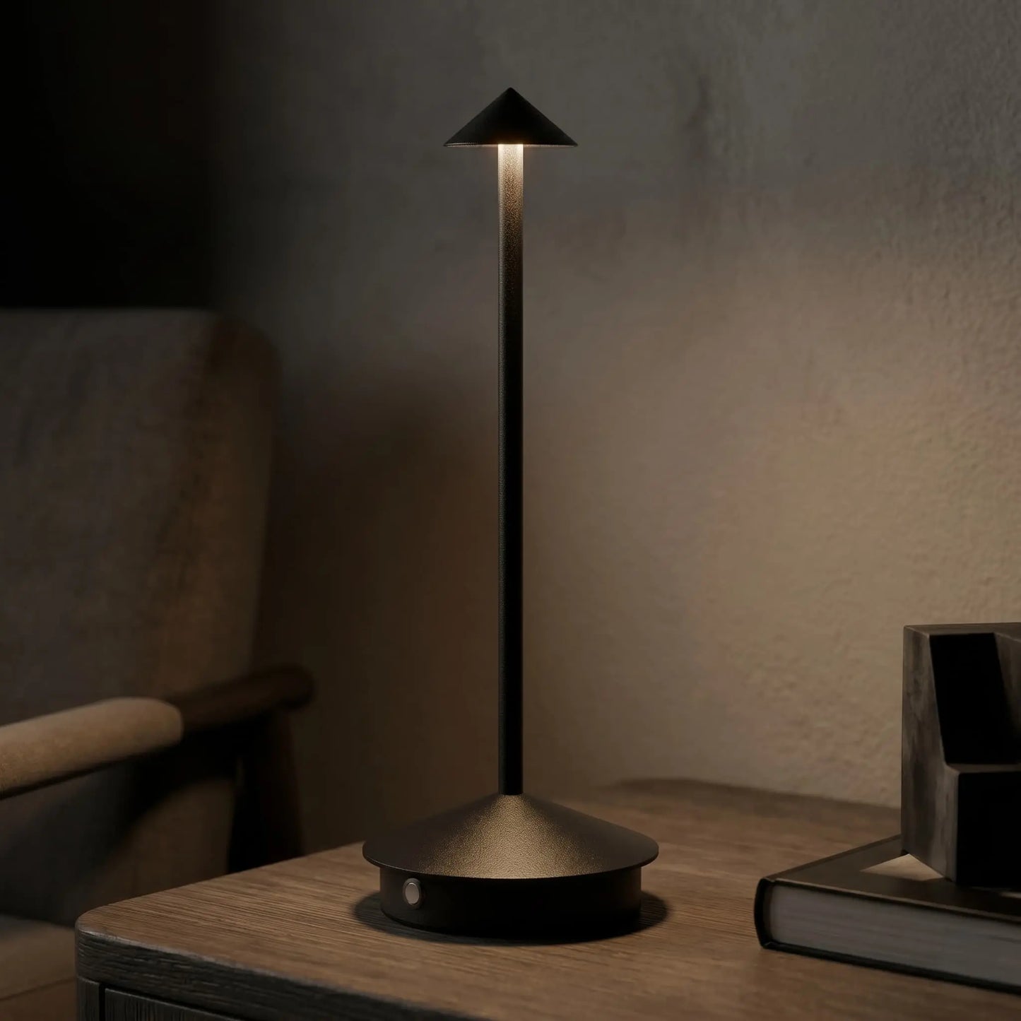 Aesthix Lume Vela slim rechargeable lamp glowing against a dark textured wall